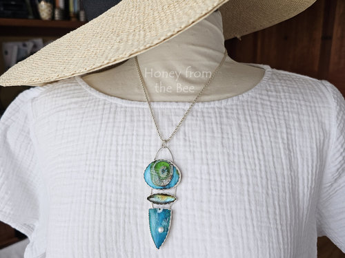 Stunning art pendant on model.