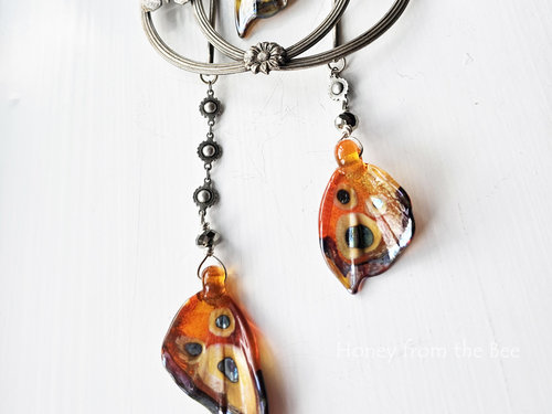 Orange butterfly wing dangles on this statement necklace.