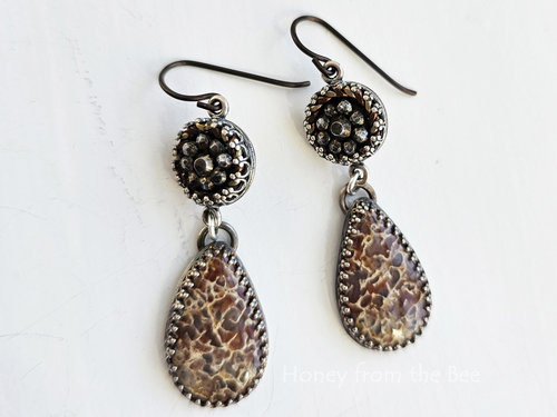 Fossilized Dinosaur bone cabochon teardrop dangles from antique steel cut button in this pair of one of a kind earrings