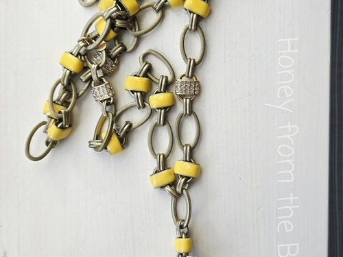 Black and yellow necklace is tunic length and features daisy motif