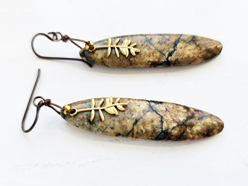 Nature inspired artisan earrings with a tan stone with dark teal lines and a brass Tamarack branch charm.