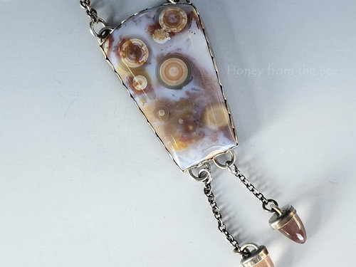 Old stock ocean jasper in palest lavender with orange orbs pair with dangling sunstones in this artisan necklace.