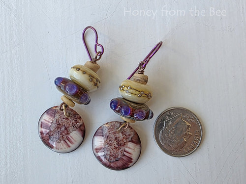Artisan earrings feature lampwork in cream and red and purple