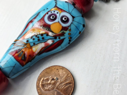 Statement necklace features owl in red and turquoise
