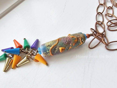 One of a kind artisan necklace features colorful lampwork and a colorful fringe