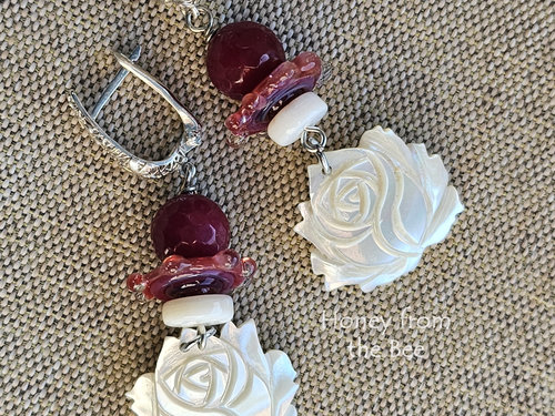 One of a kind artisan earrings feature faceted ruby quartz and creamy mother of pearl.