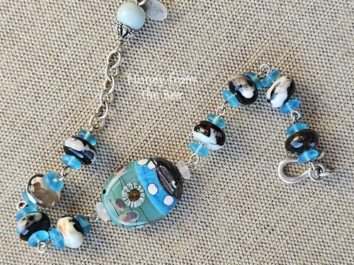 Celadon and aqua lampwork bead by Lori Lochner is the focal in this one of a kind artisan bracelet.