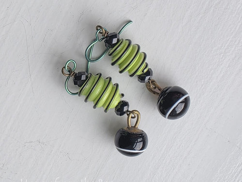 Light green and black earrings feature lampwork and crystals