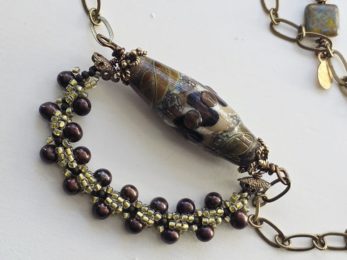 Brown beaded necklace features lampwork focal and brown pearls