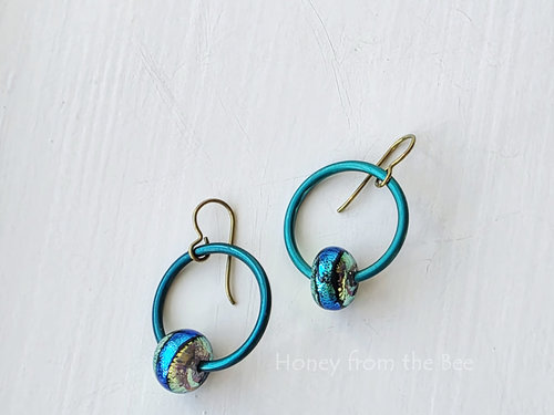 colorful earrings in teal and chartreuse feature lampwork and anodized aluminum