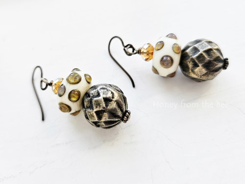 Playful artisan earrings in shades of white, yellow and grey.