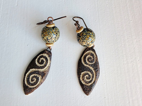 Earthtone earrings feature lampwork in brown, cream and black with a ceramic drop that has a swirl on it