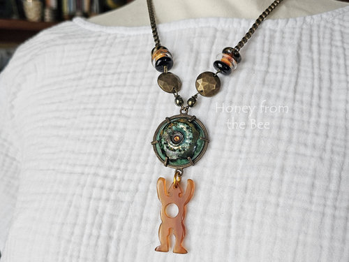 Talisman statement necklace with ceramic in green and man shaped bone charm