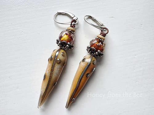 Statement earrings feature lampwork and sterling silver in orange and cream