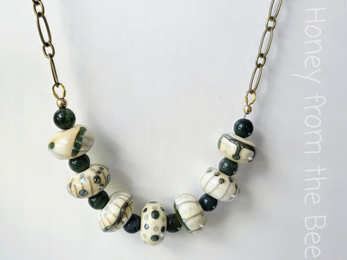 Green and white necklace features lampwork and moss agate