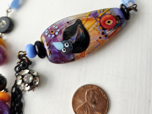 Purple, orange and blue necklace features crow lampwork
