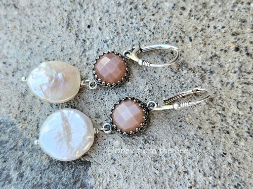 Iridescent coin pearls dangle from shimmering peach moonstones in these feminine earrings