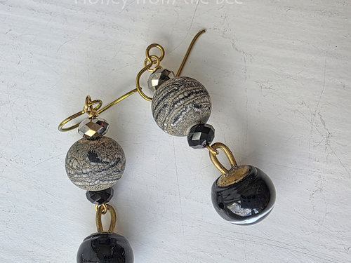 Black and gold artisan earrings feature lampwork and antique buttons