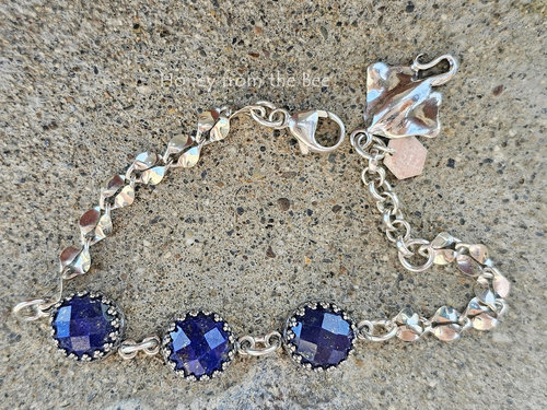 Silver bracelet with navy blue gemstones and a stingray charm.