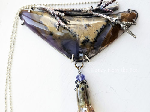 Triangular shaped Amethyst Sage Agate with a lampwork flower dangle in a golden glow pendant necklace