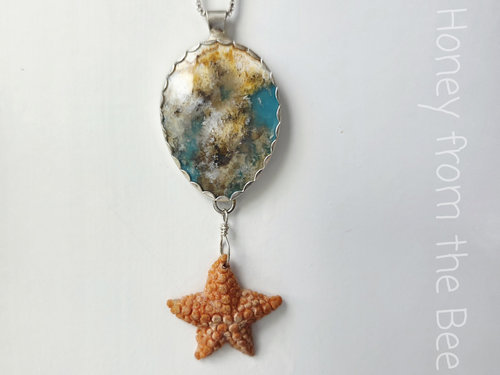 Sterling silver pendant features plume agate and starfish dangle