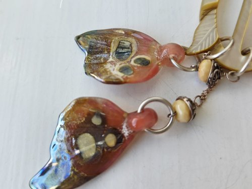 Pink and cream pendant is nature inspired with butterfly wings in glass