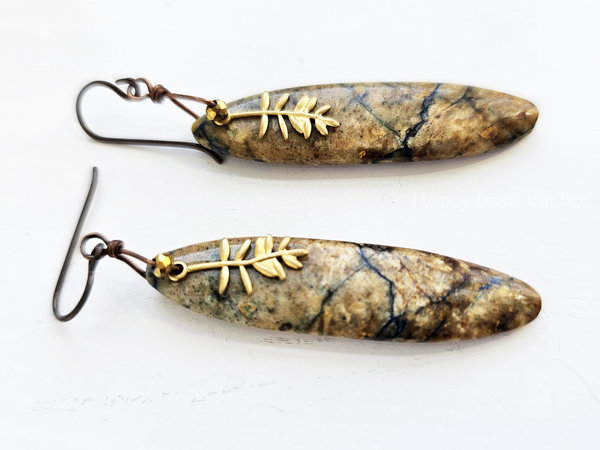 Nature inspired artisan earrings with a tan stone with dark teal lines and a brass Tamarack branch charm.