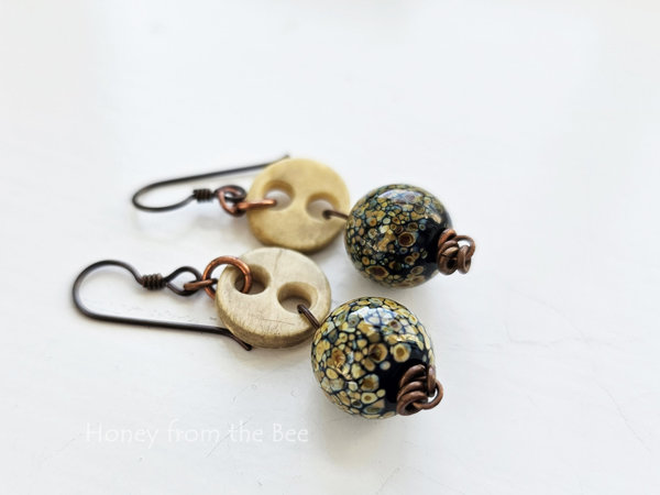 Boho style earrings feature antique bone buttons and raku frit lampwork