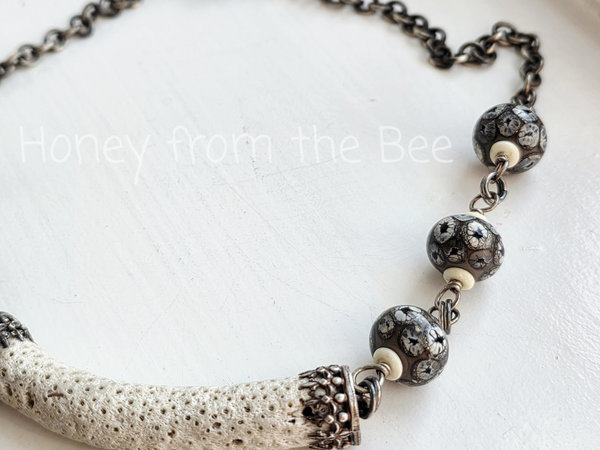 Black and white necklace features white coral and lampwork