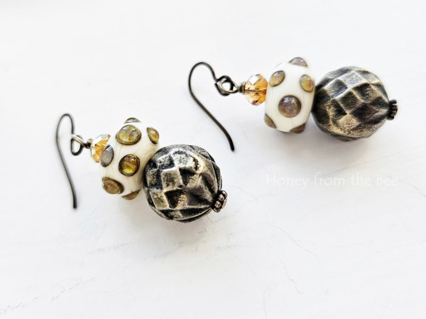 Playful artisan earrings in shades of white, yellow and grey.