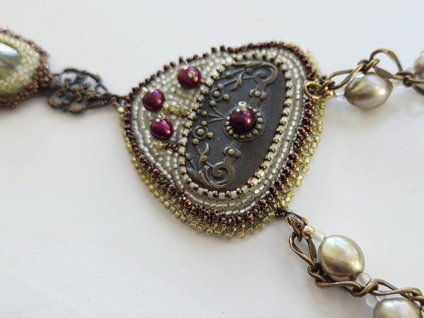 Bead embroidered statement necklace in brass, white, green and red